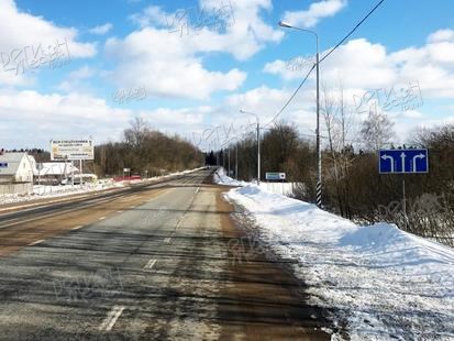 д. Лужки, напротив поворота в д. Веретенки, Волоколамское шоссе, при движении в область, справа Б